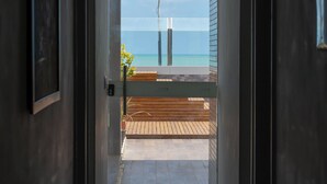 A hallway leading to a balcony with a view of the ocean. - Bessa Golden Flats (João Pessoa)