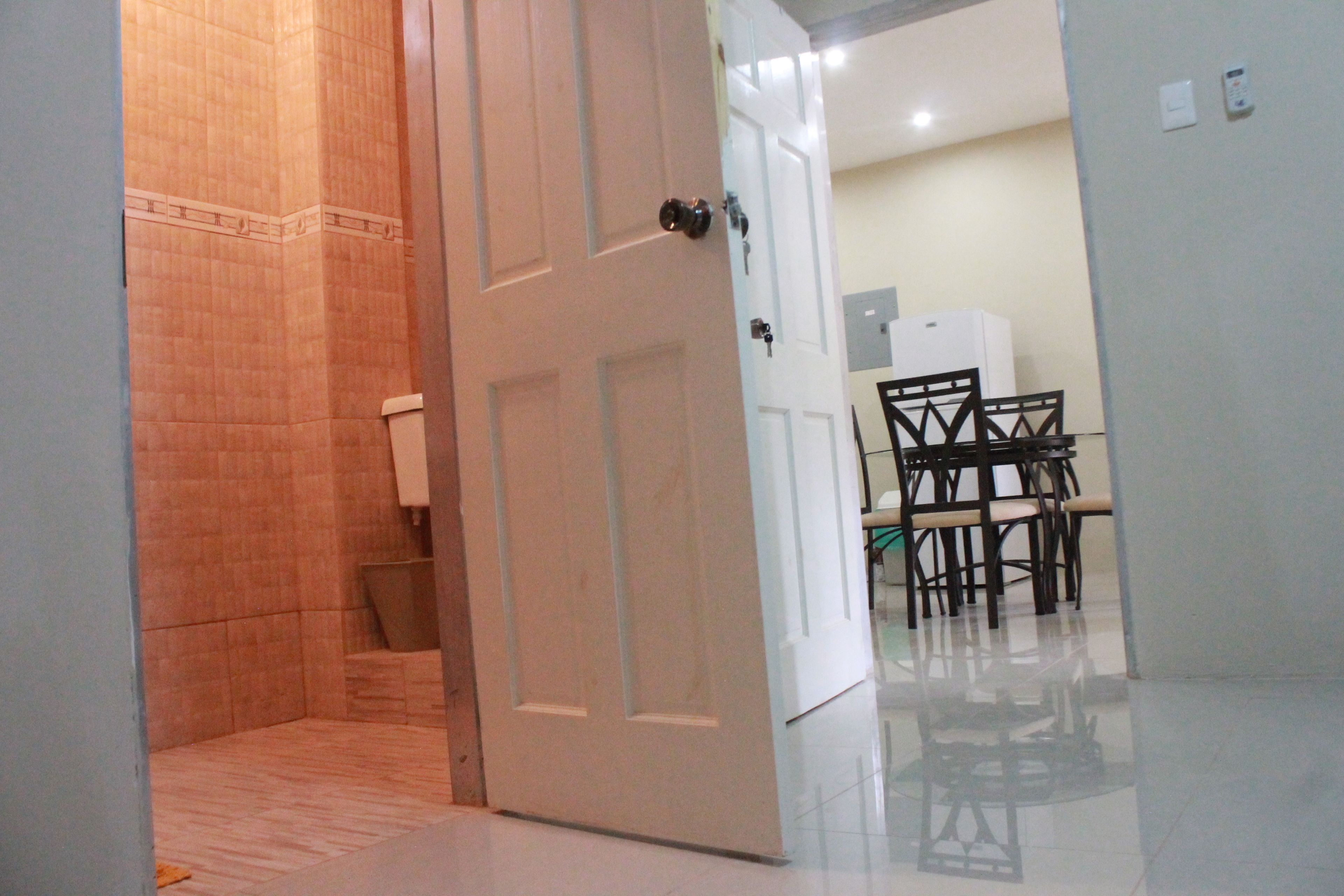 An open door leading to a dining area with a table and chairs.