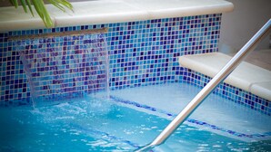 A swimming pool with a tiled edge and a metal ladder. - Robbie's Place Tobago (Black Rock)