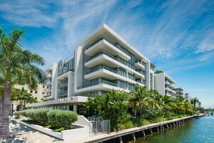 Un hotel moderno de varios pisos con balcones, situado junto a la costa.