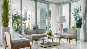 A modern living room with a sofa set, a coffee table, and a lamp. - The Altair Bay Harbor Hotel (Bay Harbor Islands)