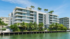 A modern multi-story hotel with balconies, located near a waterfront with palm trees. - The Altair Bay Harbor Hotel (Bay Harbor Islands)