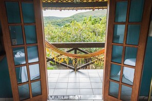 Une pièce offrant une vue sur un paysage verdoyant grâce à une porte en bois dotée de panneaux de verre.