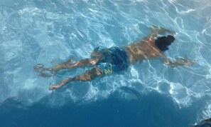 Una persona nadando en una piscina.