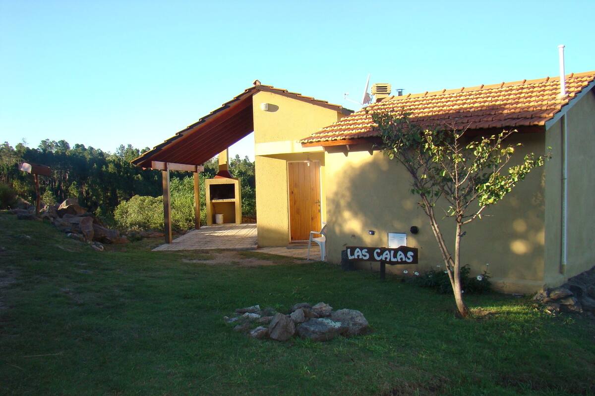 Uma casa com telhado de cerâmica, porta de madeira e uma placa com a inscrição 'LAS CALAS'.