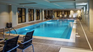 An indoor swimming pool with clear water, surrounded by lounge chairs and a tiled floor. - Hampton Inn & Suites Foxborough/Mansfield (Foxborough)