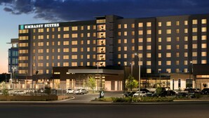 A large, modern hotel with multiple floors and a prominent sign reading "Embassy Suites". - Embassy Suites by Hilton San Antonio Landmark (San Antonio)