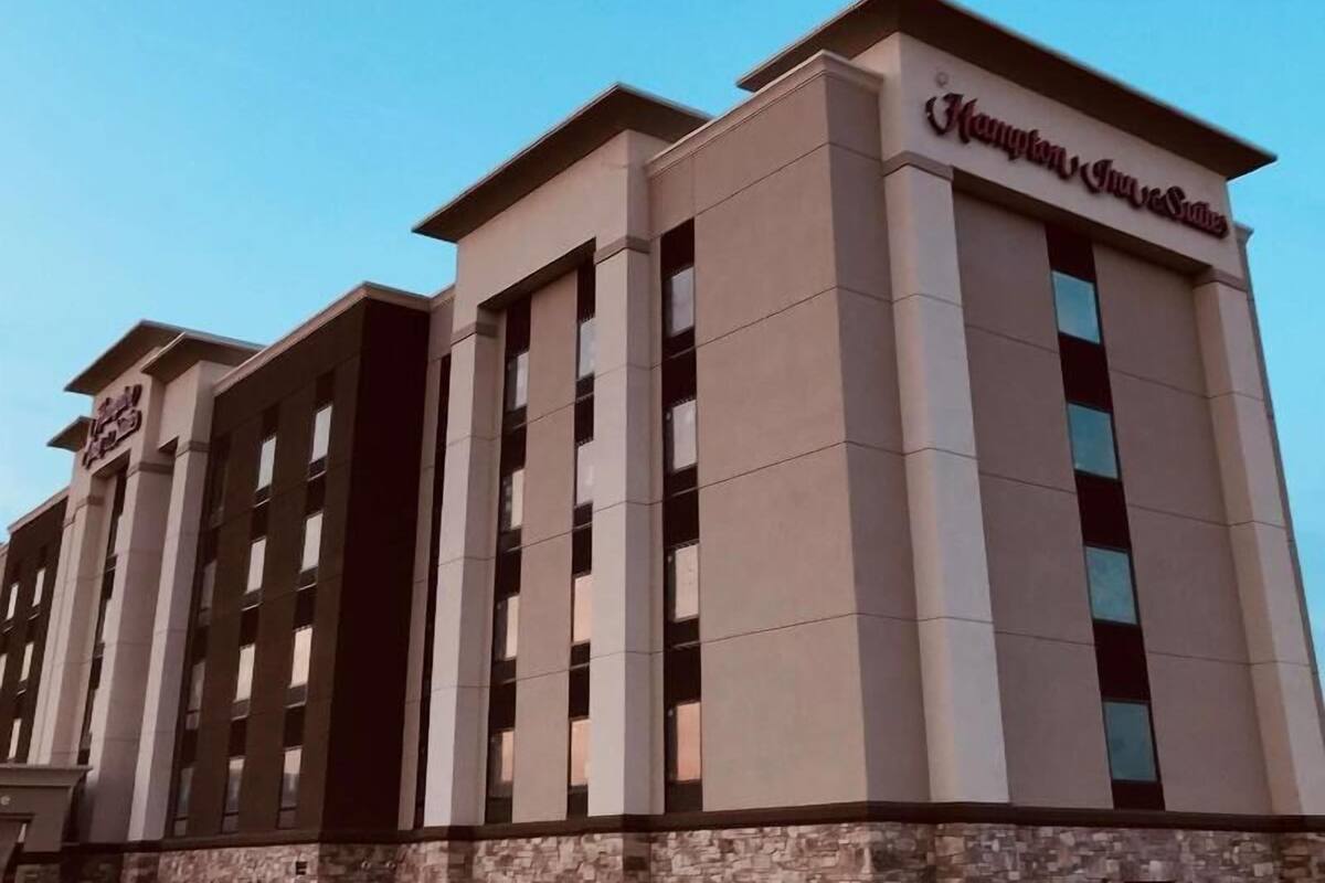 A multi-story hotel with a stone facade and a flat roof.