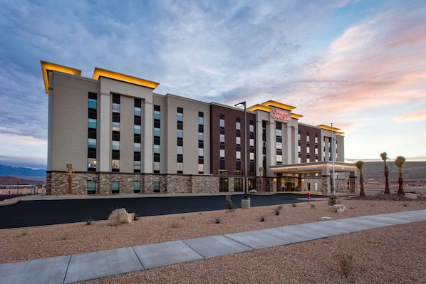 A modern hotel with a flat roof, multiple floors, and a prominent entrance with a canopy.