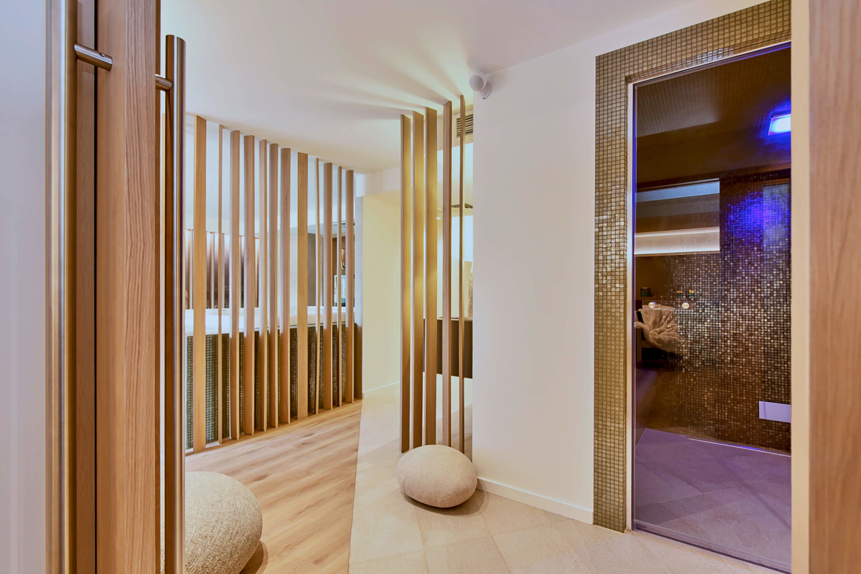 A modern interior with a wooden floor, a glass partition, and a round seating area.