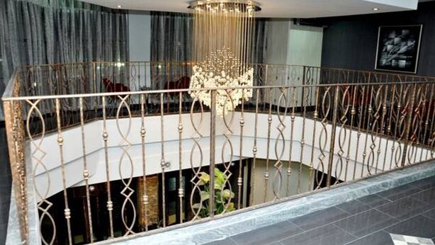 A modern interior with a circular balcony, a chandelier, and a view of the interior space. - De Edge Hotel (Port Harcourt)