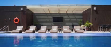 A swimming pool with lounge chairs and a lifebuoy.