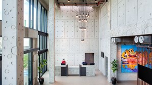 A modern lobby with a reception desk, large windows, and a unique wall design. - Ibis Styles Kota Kinabalu Inanam Hotel (Kota Kinabalu)