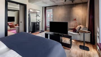 Een moderne hotelkamer met een groot bed, een flatscreen televisie, een bureau en een bank.