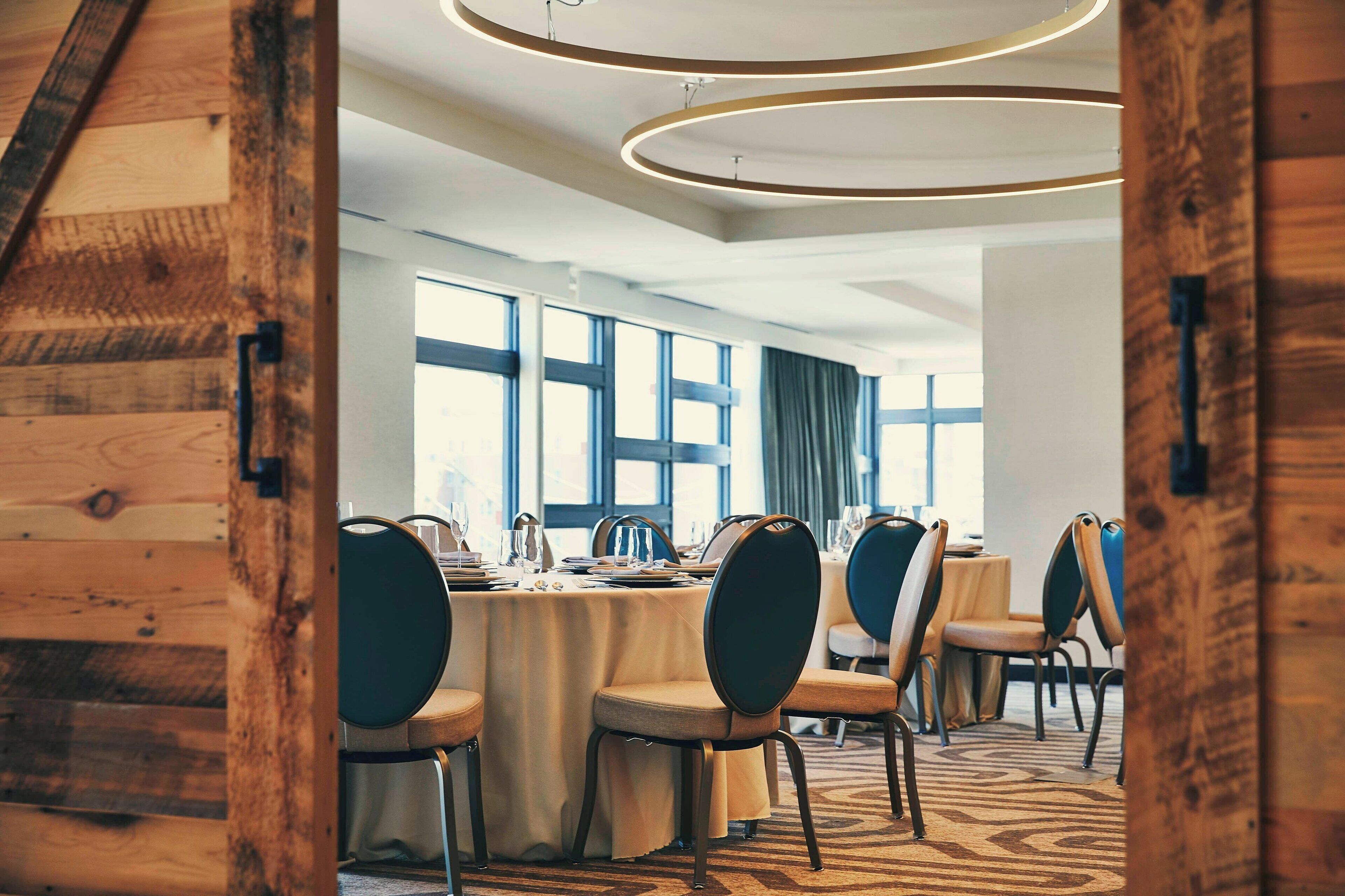 A conference room with a long table, chairs, and large windows.