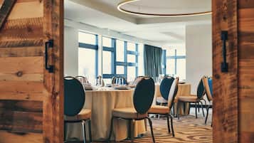 A conference room with a long table, chairs, and large windows.