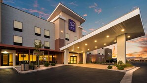 Edificio di un Sleep Inn & Suites con ingresso coperto, posti a sedere esterni e area verde curata.