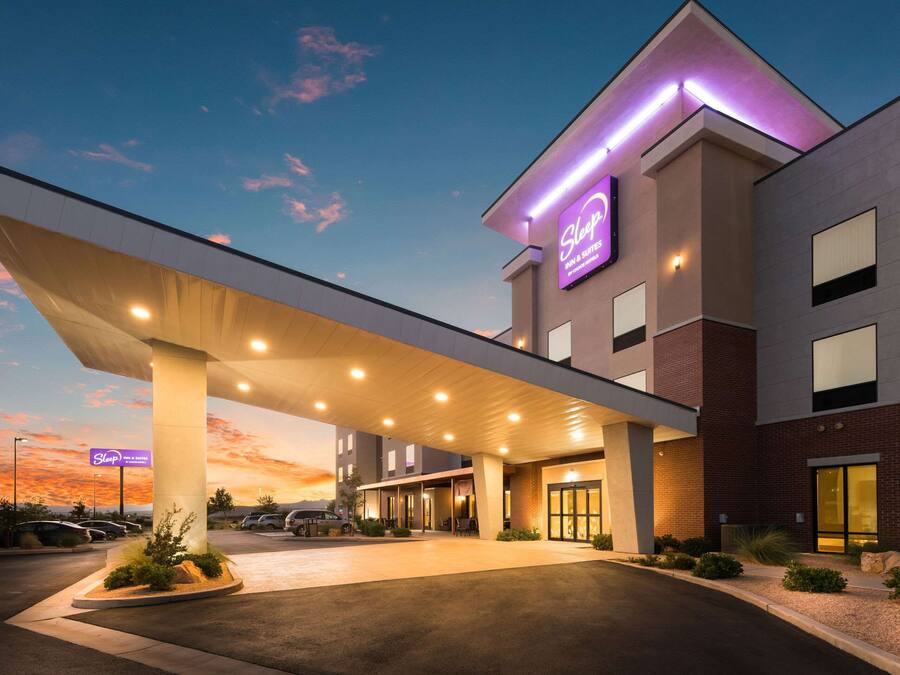 A hotel with a modern design, featuring a covered entrance and a prominent sign.