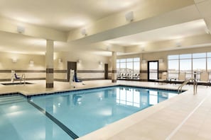 A large indoor swimming pool with clear blue water, surrounded by lounge chairs and a high ceiling with recessed lighting. - Courtyard by Marriott St Paul Woodbury (Woodbury)