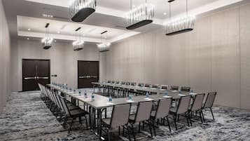 A conference room with long tables, chairs, and water bottles.