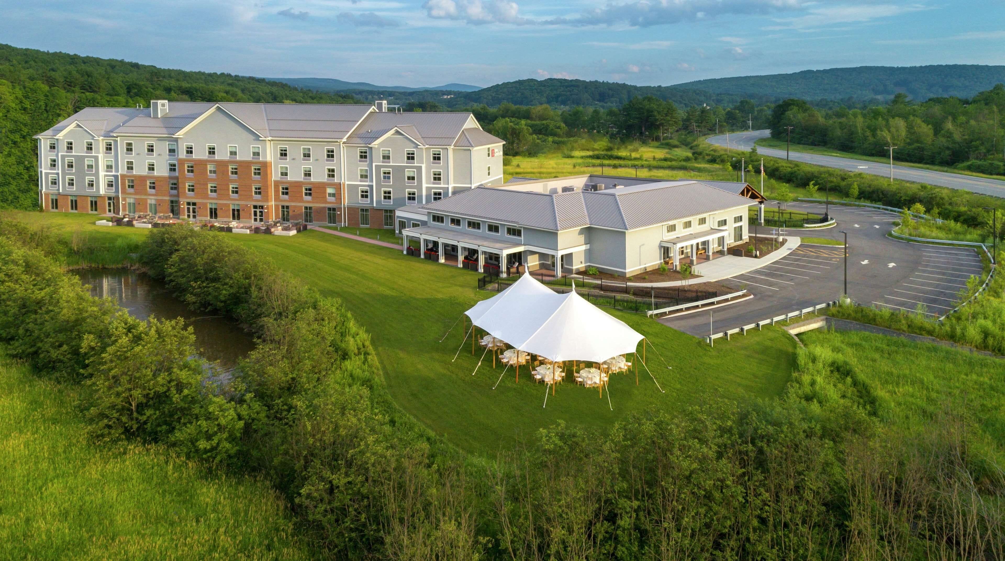 A large hotel with multiple buildings, a parking lot, and a tent set up for an event.