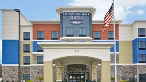 A hotel entrance with a sign reading "Homewood Suites Hilton" and the number 231.