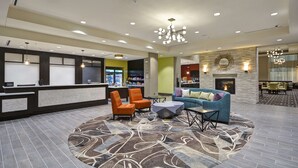 A lobby with a reception desk, seating area, and a fireplace.