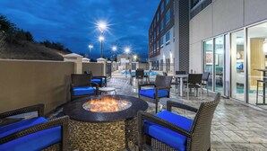 An outdoor patio area with a fire pit, seating, and a pool. - Holiday Inn Express & Suites Gainesville - Lake Lanier Area by IHG (Gainesville)