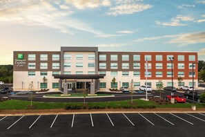A Holiday Inn Express building with a modern design, multiple parking spaces, and a landscaped entrance area. - Holiday Inn Express & Suites Gainesville - Lake Lanier Area by IHG (Gainesville)