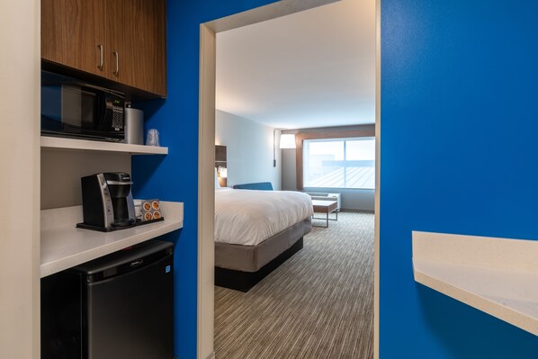 A hotel room with a bed, a coffee machine, a microwave, and a small refrigerator. - Holiday Inn Express & Suites Gainesville - Lake Lanier Area by IHG (Gainesville)