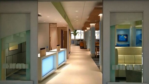 A modern hotel lobby with a reception desk, seating area, and a television screen. - Holiday Inn Express & Suites Gainesville - Lake Lanier Area by IHG (Gainesville)