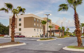 A hotel with a modern design, featuring a parking lot and palm trees. - Holiday Inn Express Fort Walton Beach Central by IHG (Fort Walton Beach)