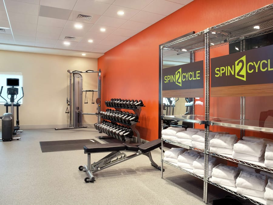 A gym with weight racks, dumbbells, and a bench.