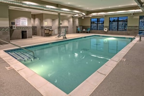 Relax by the rectangular pool surrounded by a tiled deck and enjoy a view of the outside through the windows.