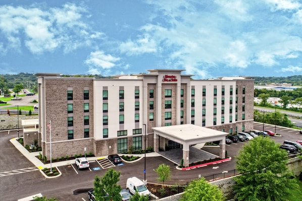 Welcome to Hampton Inn & Suites, featuring a symmetrical facade and lush surroundings.