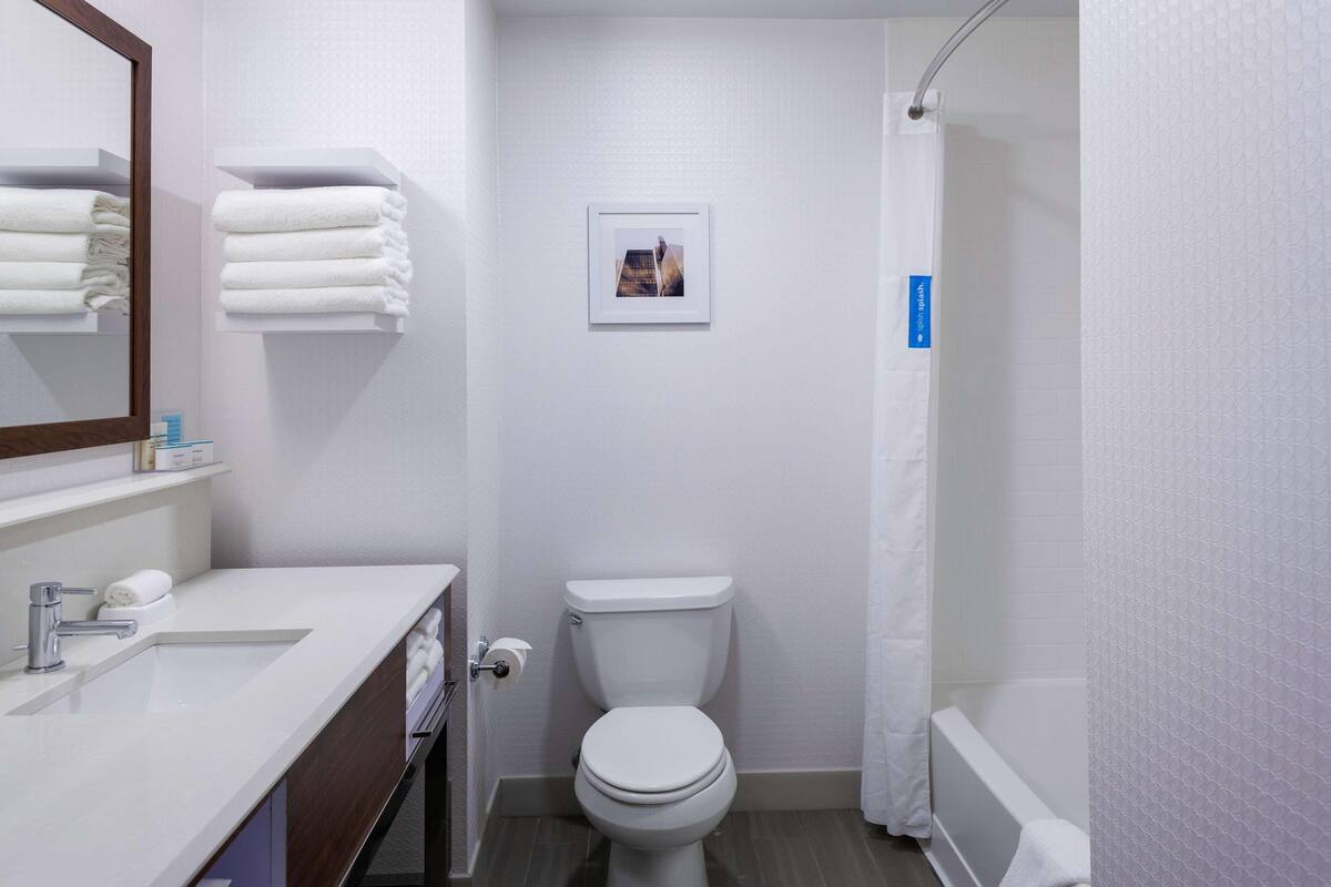 A modern bathroom with a toilet, sink, and shower.