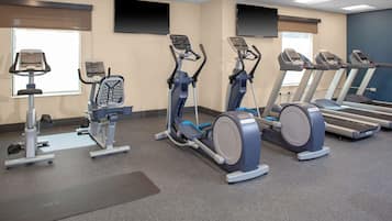 A gym with treadmills, elliptical machines, and a stationary bike.