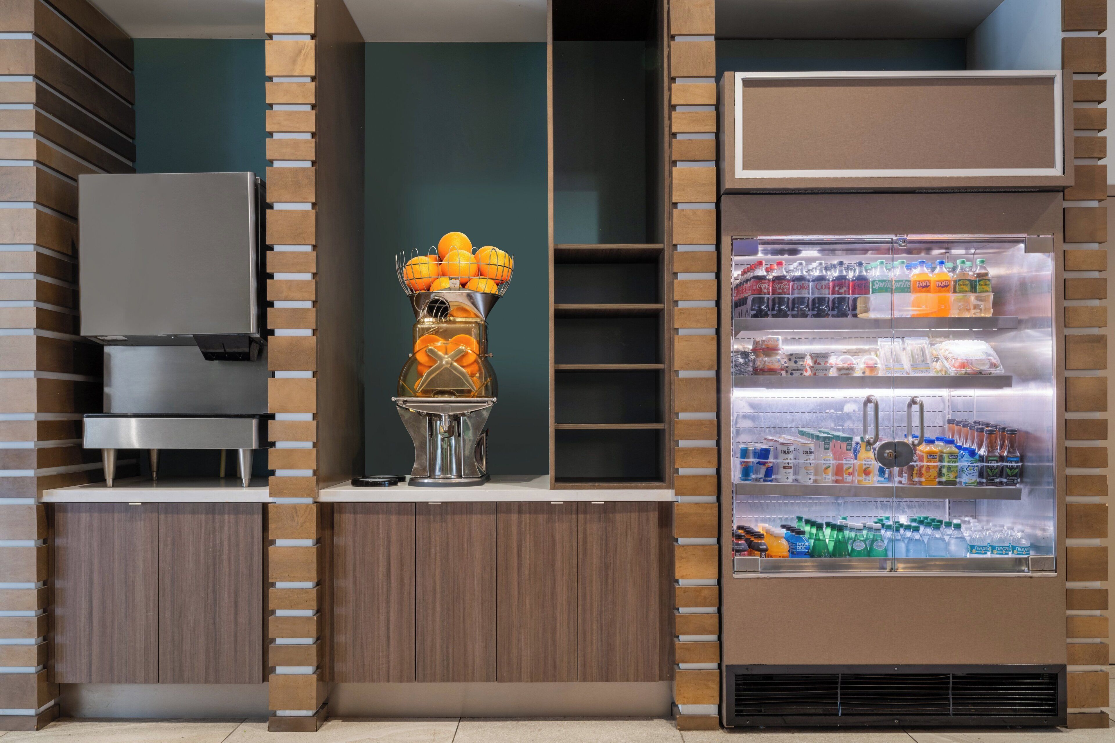 A kitchenette with a refrigerator, a sink, and a fruit bowl.