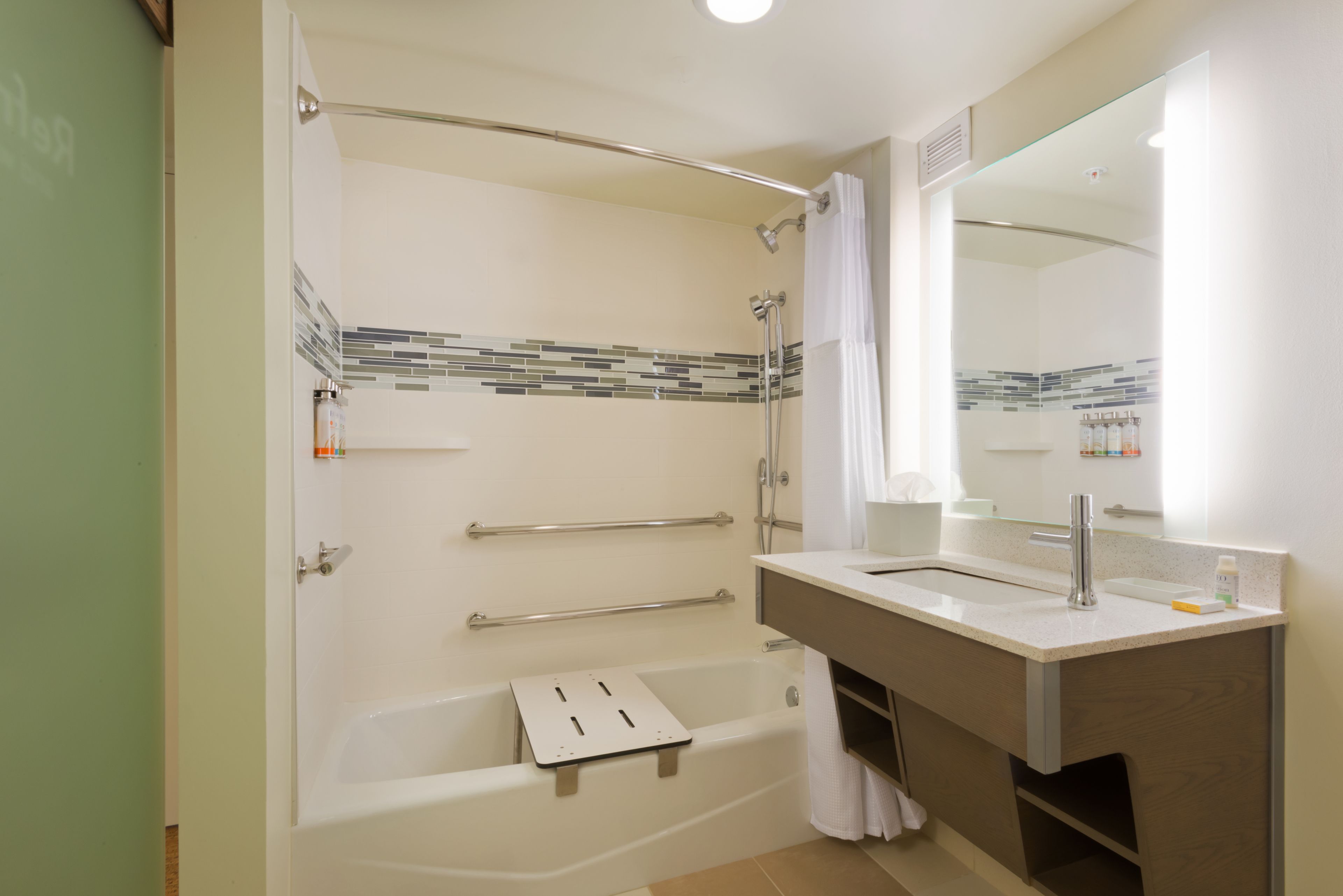 Une salle de bain moderne équipée d’une baignoire, d’une douche, d’un meuble-lavabo et d’un miroir.