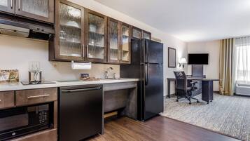A modern kitchen with a built-in dishwasher, a refrigerator, and a microwave.