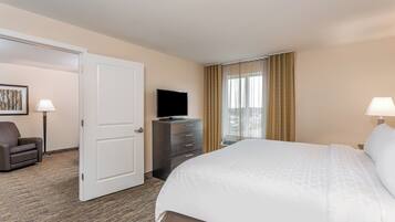 A hotel room with a bed, a dresser, a television, and a chair.