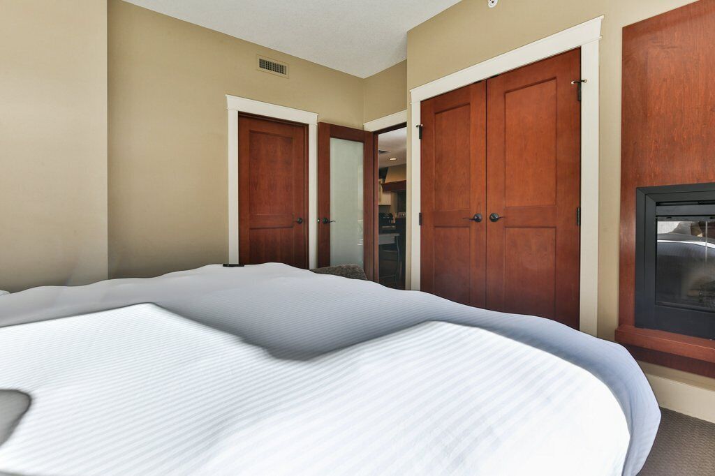 Ein Hotelzimmer mit einem großen Bett, zwei Holzschränken und einem Fenster mit Blick.