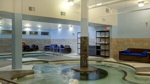 A spa area with a hot tub, seating, and a reception desk. - Bow 221 | Resort Suite with Pool & Hot Tub (Canmore)