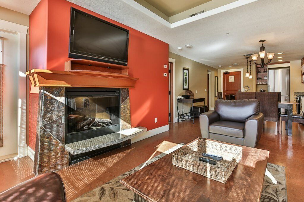A modern living room with a fireplace, a television, and a comfortable seating area.