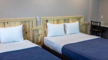 A room with two beds, each with a wooden headboard and white bedding.
