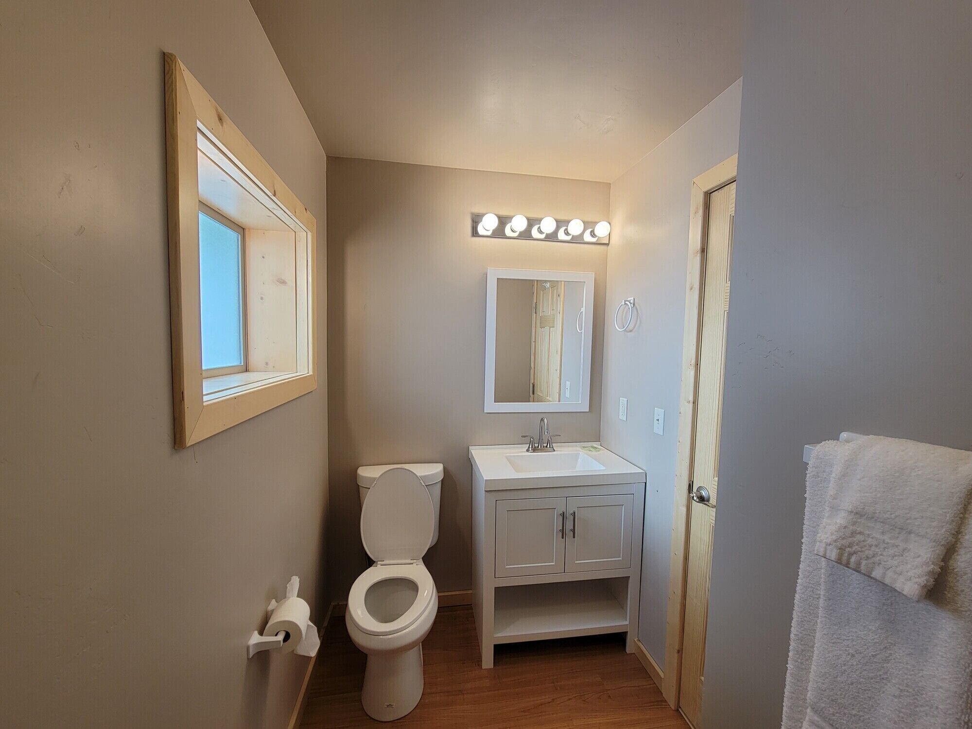 A compact bathroom with a toilet, sink, and mirror.