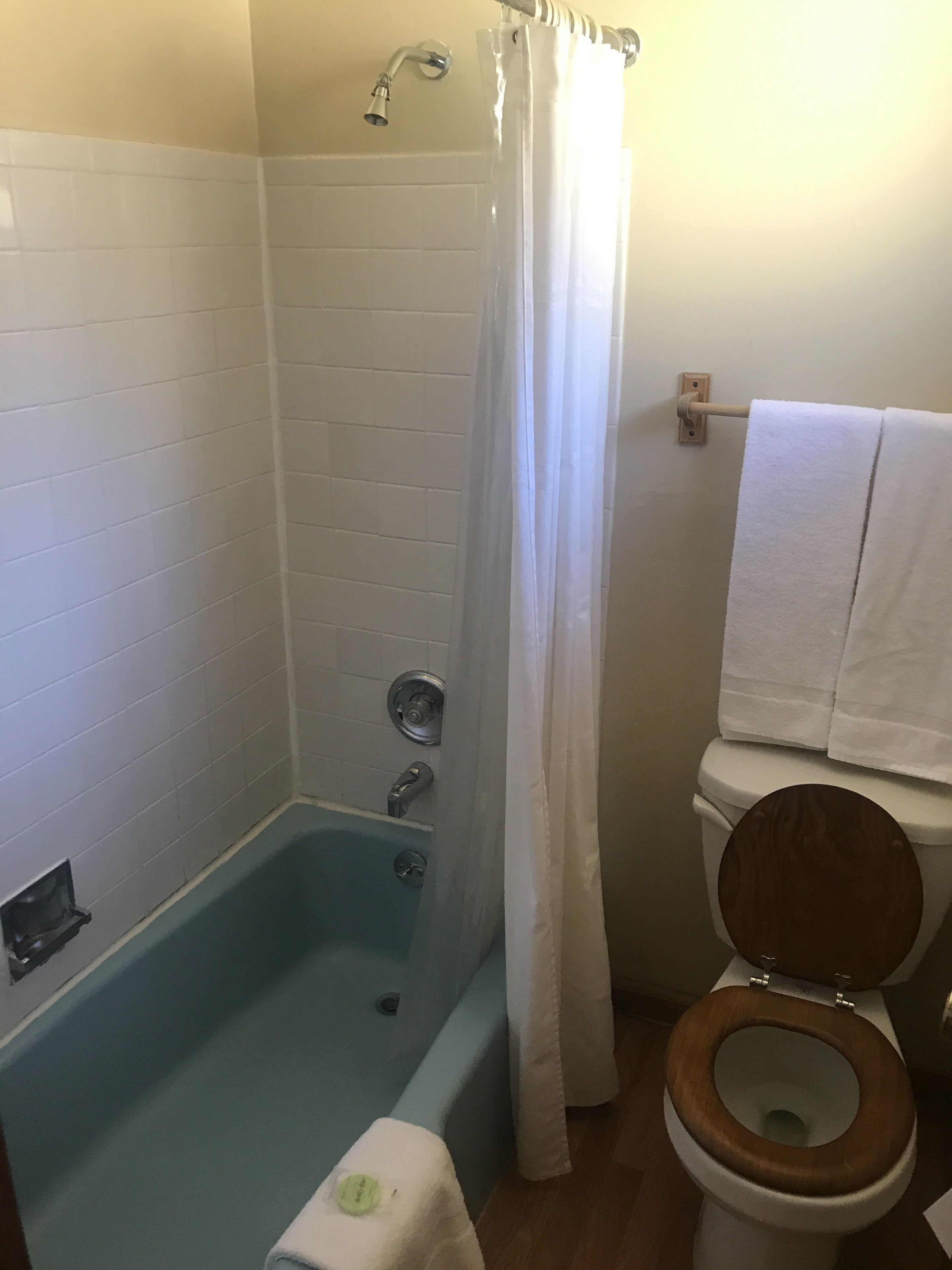 A bathroom with a bathtub, shower, and toilet.