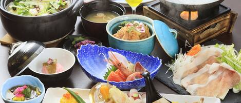 A variety of Japanese dishes including a hot pot, sashimi, and a martini glass.
