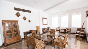 A spacious room with wooden furniture, including a cabinet, sofas, and tables.