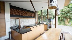 A modern kitchen with a wooden island, a sink, and a refrigerator.